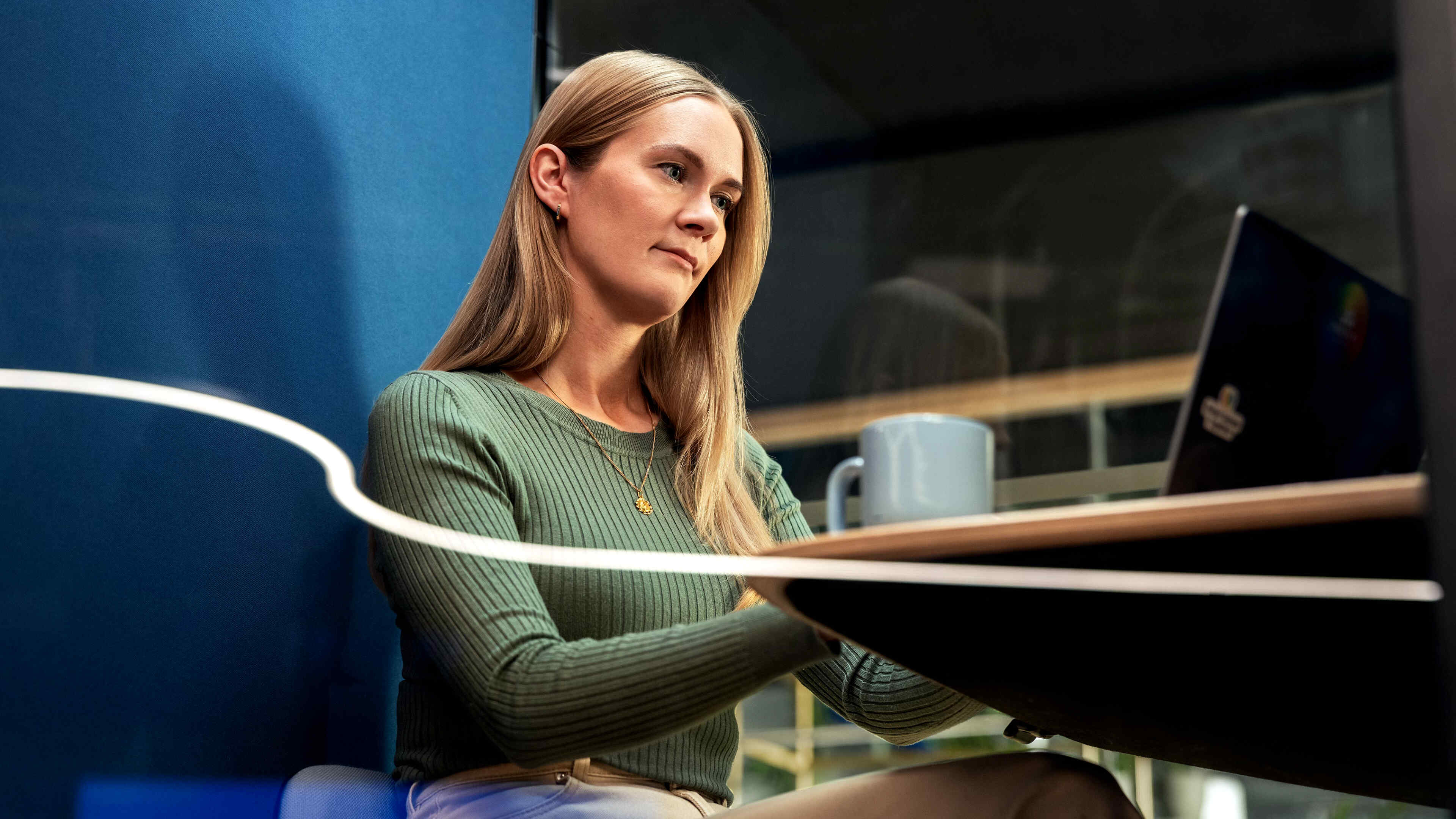 A person in a Metacore meeting booth with a cup of coffee